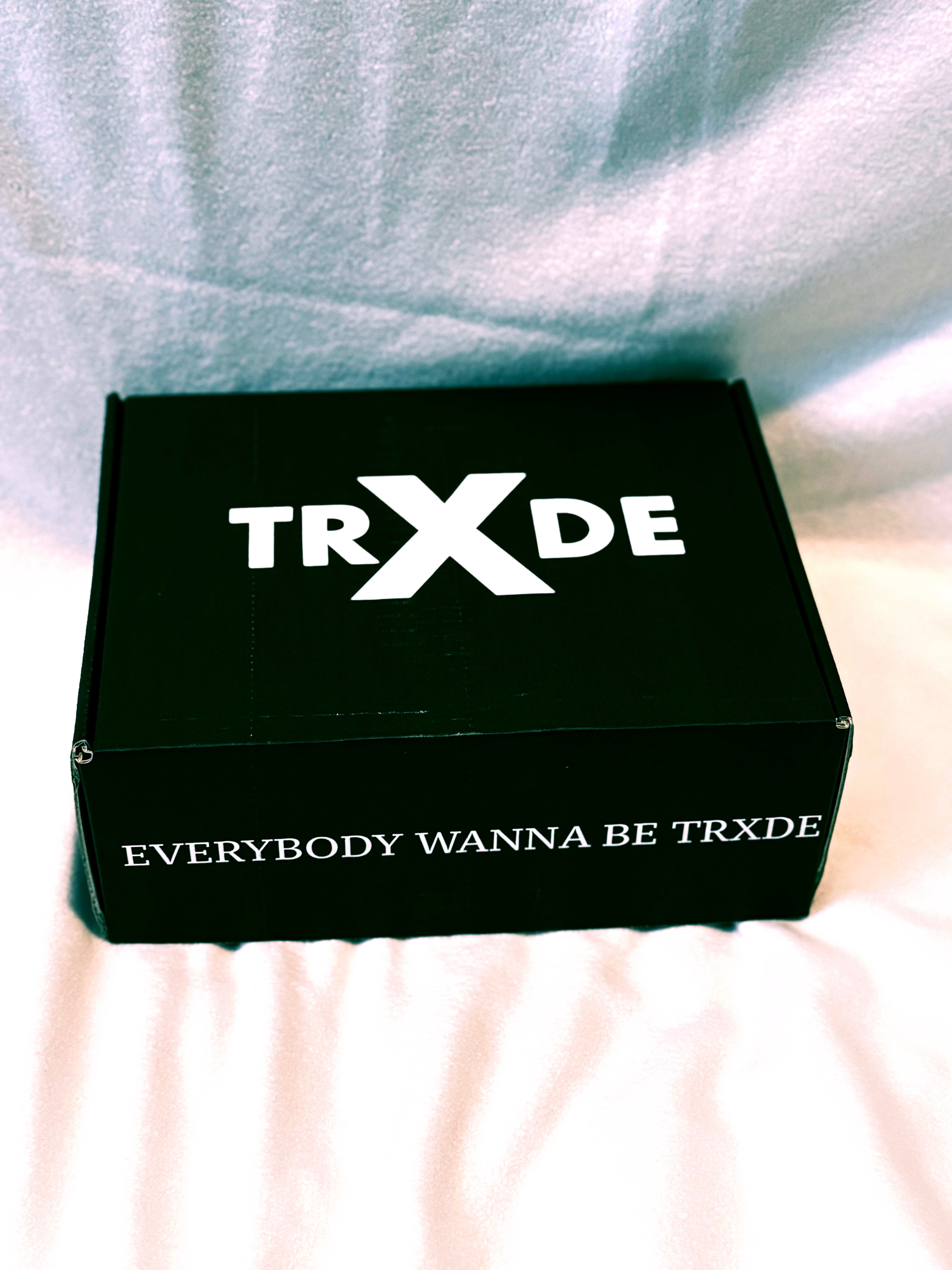Black box with 'TRXDE' branding on a light background