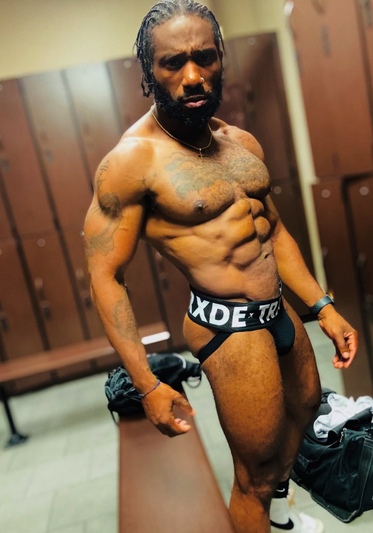 Man in black underwear standing in a locker room